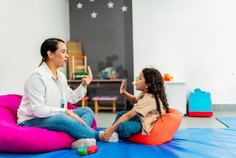 Child participating in a therapy interaction with a therapist at Keller Child and Family Therapy